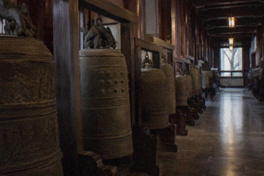 A row of ancient bronze bells on display in a museum hall