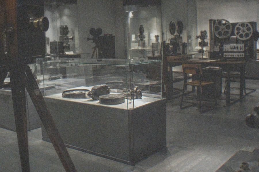Gallery of vintage film projectors and cameras displayed in glass cases inside the China National Film Museum