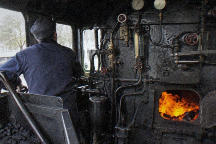 Visitors walking beside a preserved locomotive and rolling stock inside the China Railway Museum, Dongjiao Exhibition Hall in Chaoyang District
