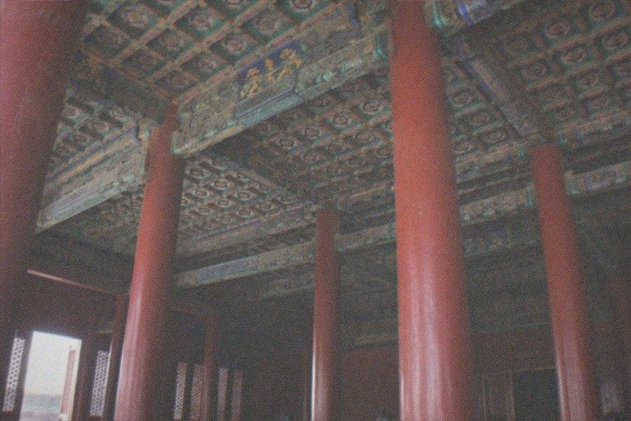 Visitors crossing the vast stone courtyard of the Palace Museum (Forbidden City) toward the side halls east of the central axis