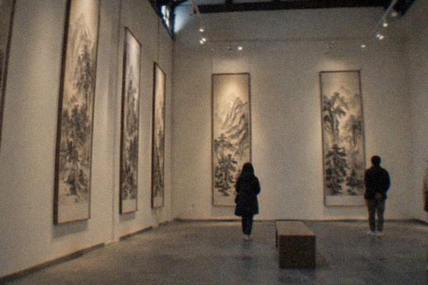 Spacious museum gallery with traditional Chinese landscape paintings on the walls