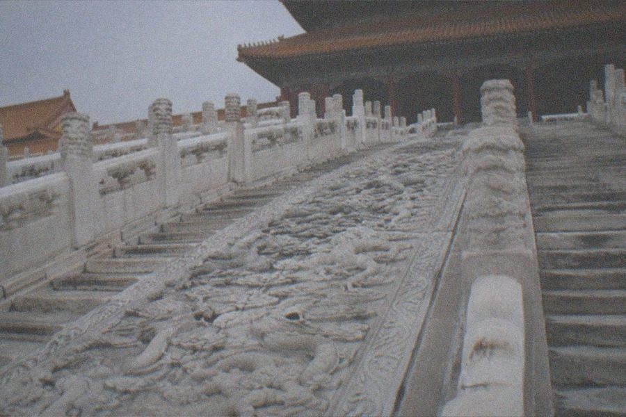 A lakeside imperial garden corridor with painted beams reflected in still water