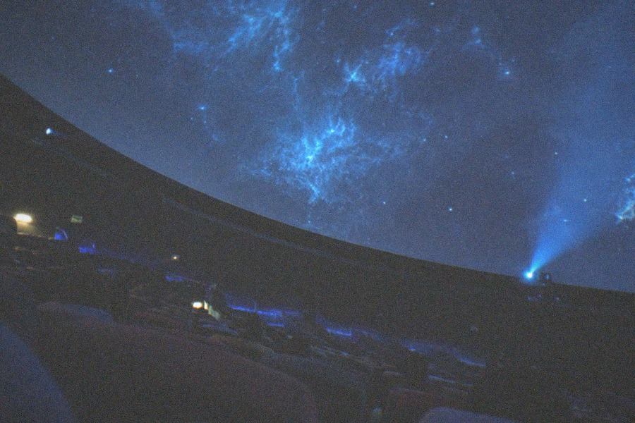 A planetarium dome theatre with rows of seats facing a curved screen