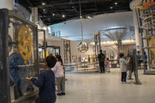 Bright modern science museum atrium with interactive exhibits on several floors